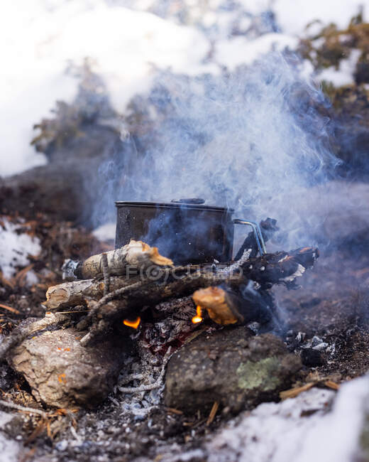 Casserole Cuisiner sur un feu de camp dans la neige, États-Unis — Photo de stock