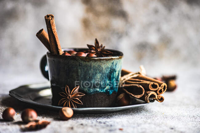 Concetto di cibo natalizio con coppa vintage piena di noci, bastoncini di cannella e stella di anice su sfondo di cemento — Foto stock