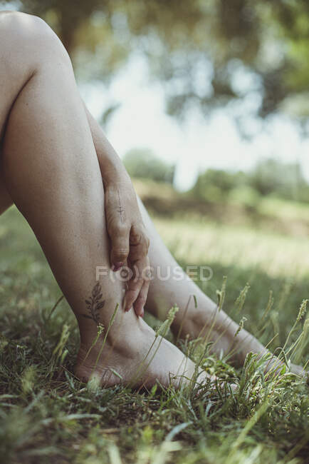 Beautiful female legs on grass lawn — Stock Photo