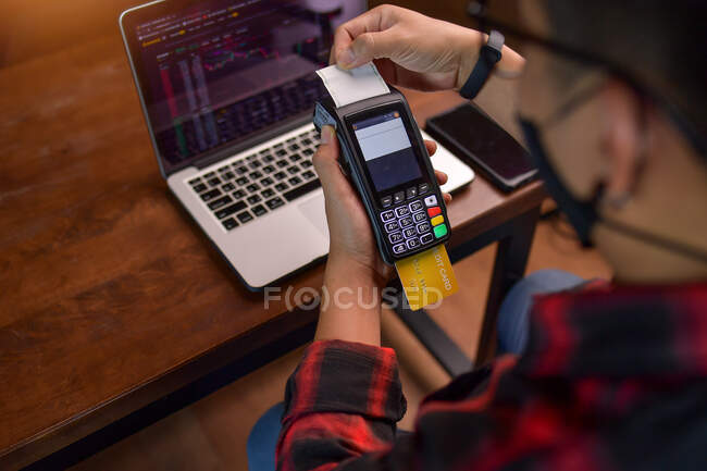 Рука людини з кредитною карткою стрибає через термінал для продажу, Закрити руки, використовуючи скандал кредитних карток, щоб заплатити, вінтажний стиль — стокове фото