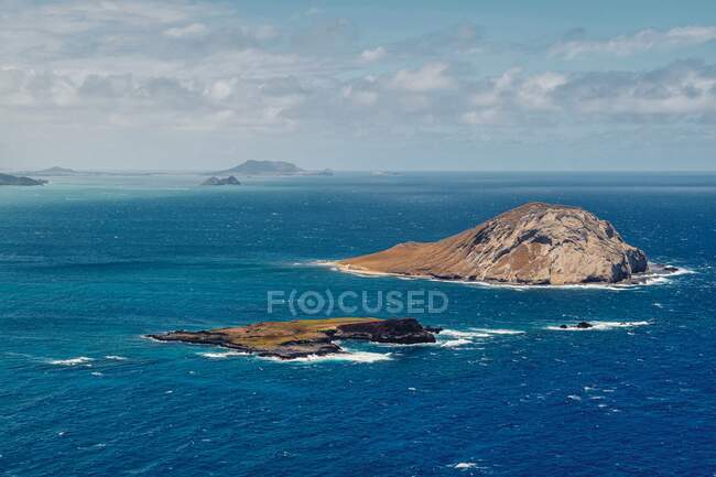 Vista ensolarada de ilhas rochosas no mar — Fotografia de Stock