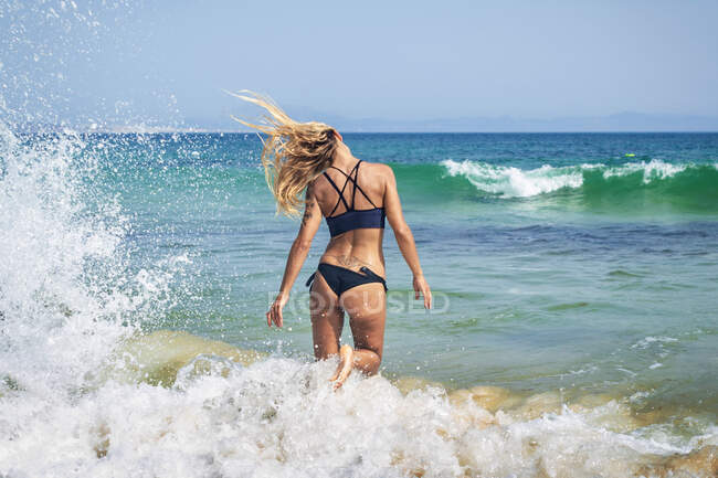 Young surfer woman at sunny beach — Stock Photo