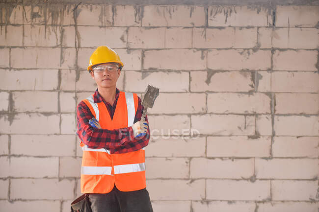 Constructor albañil tendiendo ladrillos y construyendo barbacoa en sitio industrial - foto de stock