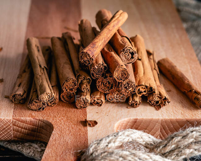 Paus de canela e especiarias no fundo de madeira — Fotografia de Stock