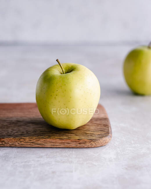 Золотое яблоко на доске — стоковое фото
