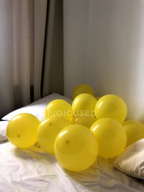 Bando de grandes balões amarelos na cama — Fotografia de Stock
