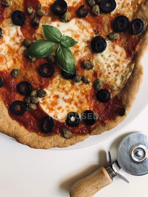 Top view of pizza with olives, capers, mozzarella, tomato and basil — Stock Photo