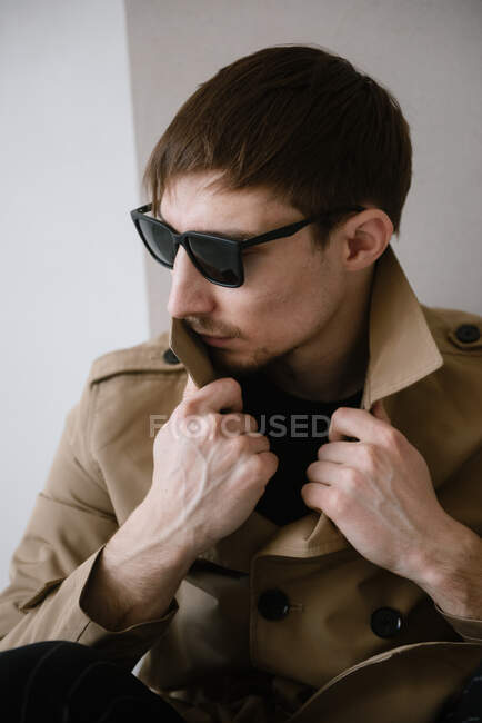 Portrait of a mysterious man wearing sunglasses and a raincoat — Stock Photo