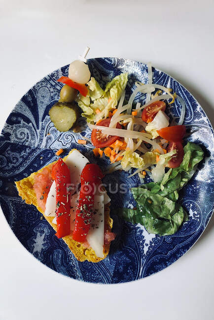 Lunch plate with gilda pintxo, salad and toast with tomato, cheese and bell pepper — Stock Photo