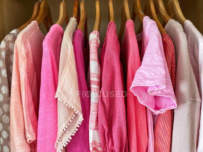 Top rosa assortiti, camicette, camicie e t-shirt appese nell'armadio — Foto stock