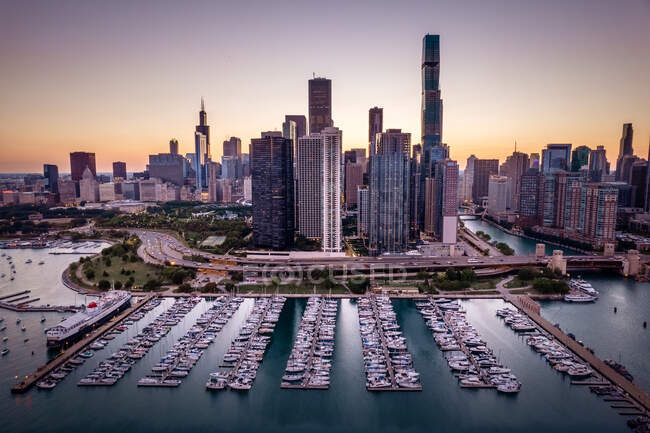 Vista aérea del horizonte de la ciudad y barcos en marina al atardecer, Chicago, Illinois, EE.UU. - foto de stock
