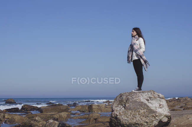 Teenage girl standing on a rock looking at view, Mar del Plata, Buenos Aires Province, Argentina — Stock Photo