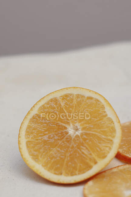 In Scheiben geschnittene Orange auf weißer Oberfläche aus nächster Nähe — Stockfoto