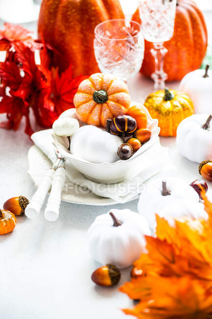 Otoño lugar de Acción de Gracias puesta en una mesa con adornos de calabaza y decoraciones de hojas - foto de stock