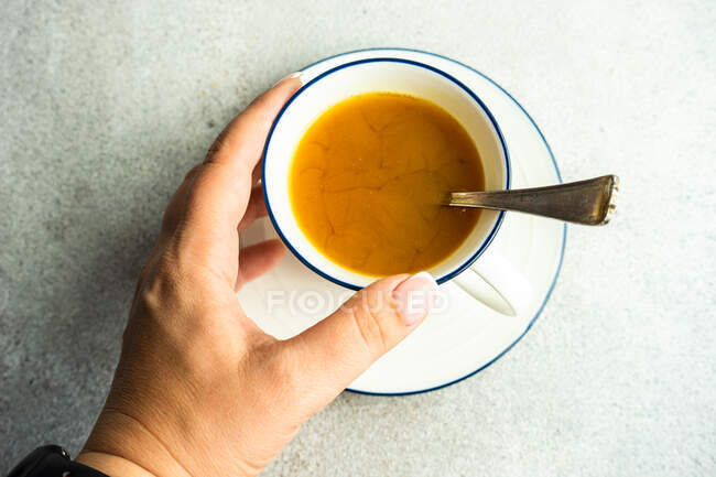 Top view of woman holding cup of turmeric tea — Stock Photo
