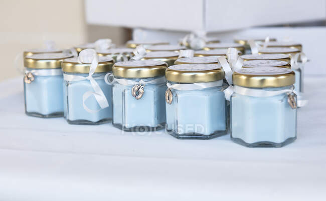Velas azules en frascos de vidrio para una ceremonia de bautismo - foto de stock