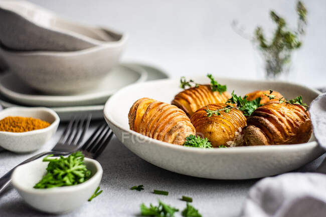 Bowl of hasselback potatoes with fresh parsley — Stock Photo