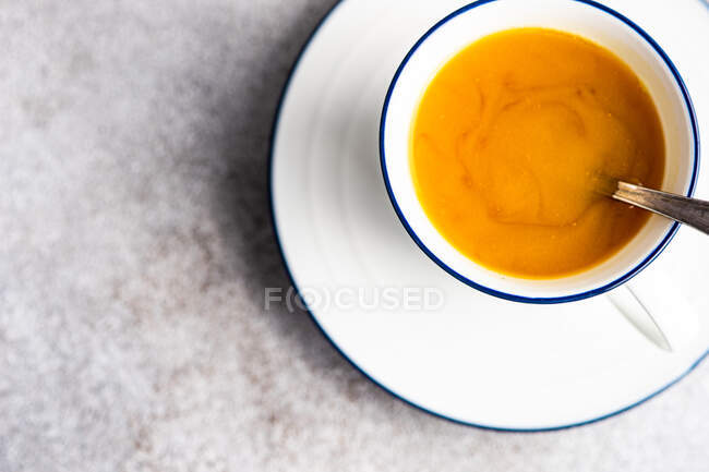 Turmeric tea with spoon in cup, top view — Stock Photo