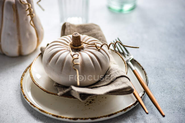 Керамічне прикраса гарбуза на тарілці за святковим столом — стокове фото