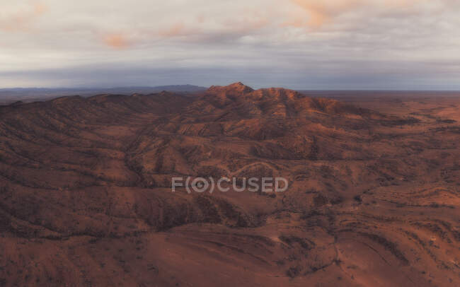 Vista aérea do deserto rochoso com céu por do sol — Fotografia de Stock