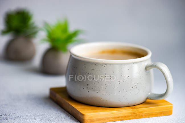 Mug of cream soup on small wooden board — Stock Photo