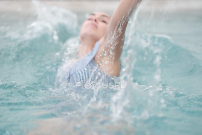 Крупним планом жінка, що плаває на фоні басейну — стокове фото