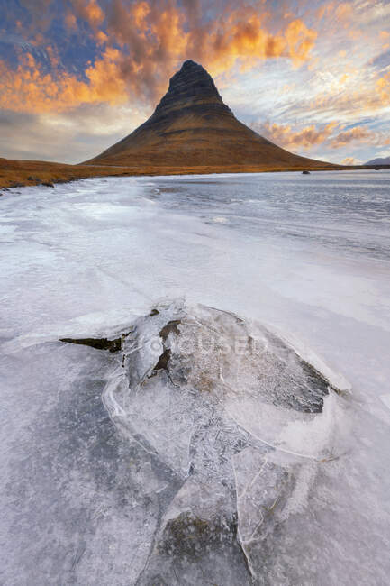 Треснувший лед и скала с красивым небом заката — стоковое фото