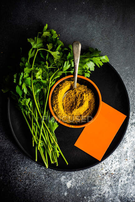 Bowl of Georgian spice, Khmeli suneli with fresh parsley and blank piece of notepaper — Stock Photo