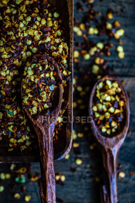 Bowl and two spoons filled with dried chili pepper flakes — Stock Photo
