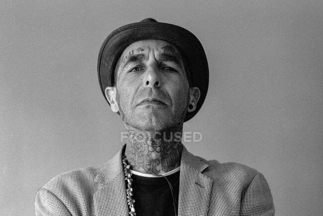 Portrait d'un homme cool avec des tatouages sur le visage et le cou — Photo de stock