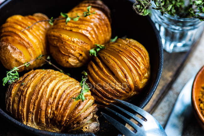 Tasty hasselback potatoes with fresh herbs — Stock Photo