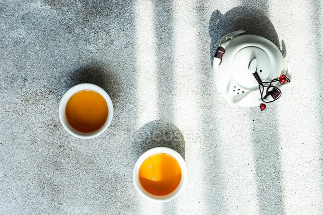 Вид сверху на две чашки чая и чайник на столе — стоковое фото
