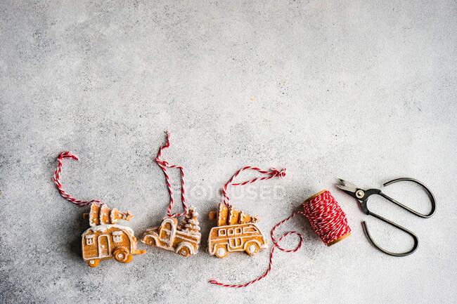 Making Christmas gingerbread truck cookie ornaments with string and scissors — Stock Photo