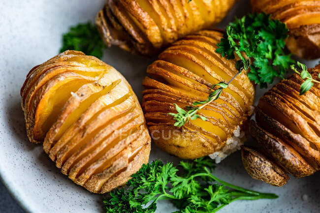 Ciotola di patate hasselback con prezzemolo fresco, colpo da vicino — Foto stock