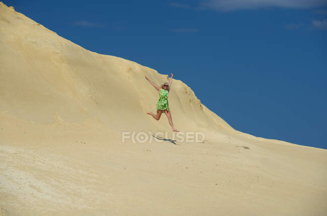 Donna che salta in aria su roccia calcarea, Gozo, Malta — Foto stock