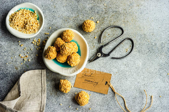 Bolas de doces caseiras saudáveis revestidas em nozes picadas na mesa de pedra — Fotografia de Stock