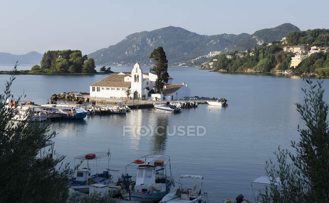 Boats moored outside Church of Panagia Vlacherna in morning, Pontikonisi, Corfu, Greece — Stock Photo