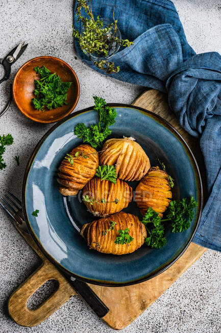 Bowl of hasselback potatoes with fresh parsley, top view — Stock Photo