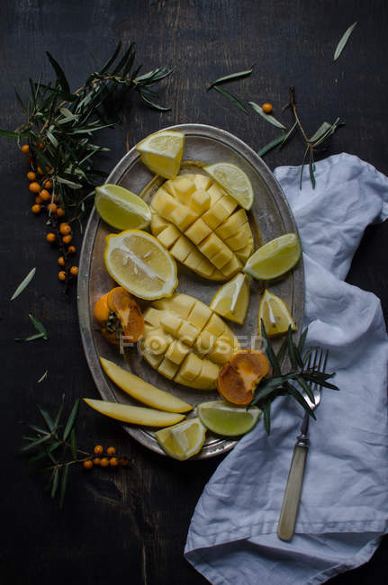 Cutted mango with fruits on vintage tray — Stock Photo