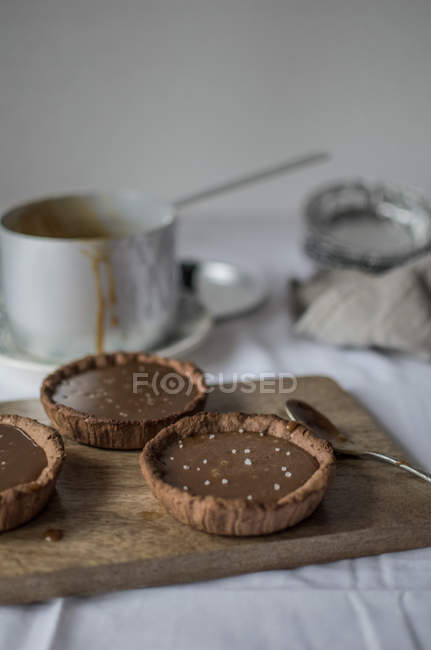 Chocolate pies on wooden platter — Stock Photo