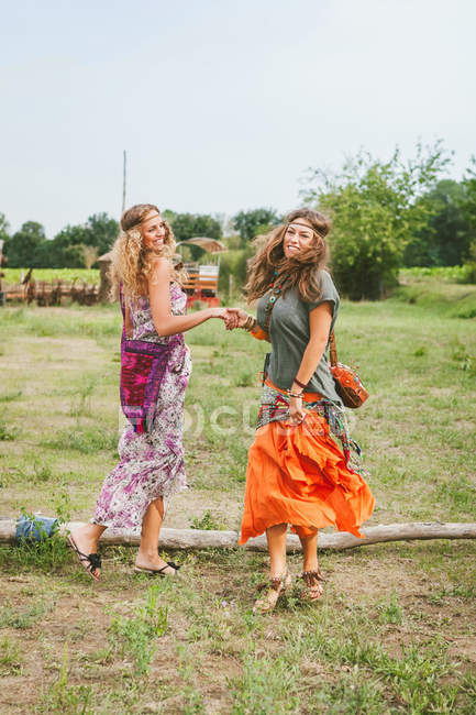 Girls in hippie style dancing on the meadow — Stock Photo