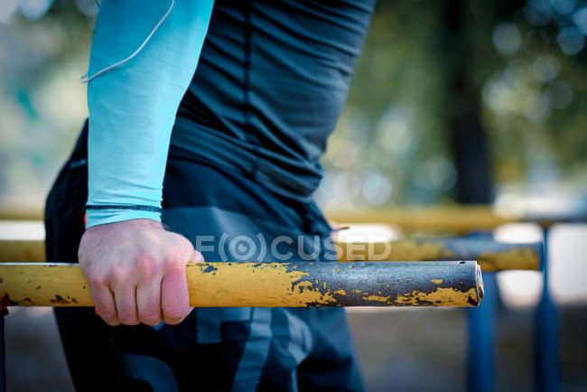 Man doing exercises on parallel bars — Stock Photo