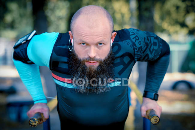 Man doing push ups on parallel bars — Stock Photo