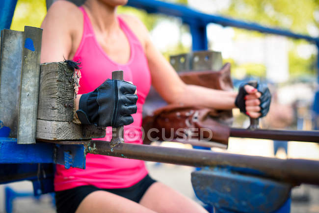 Mujer haciendo ejercicio sobre equipos deportivos - foto de stock