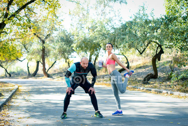 Couple étirant les muscles avant l'activité sportive — Photo de stock