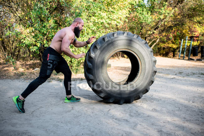 Bärtiger Mann übt mit Traktorreifen — Stockfoto