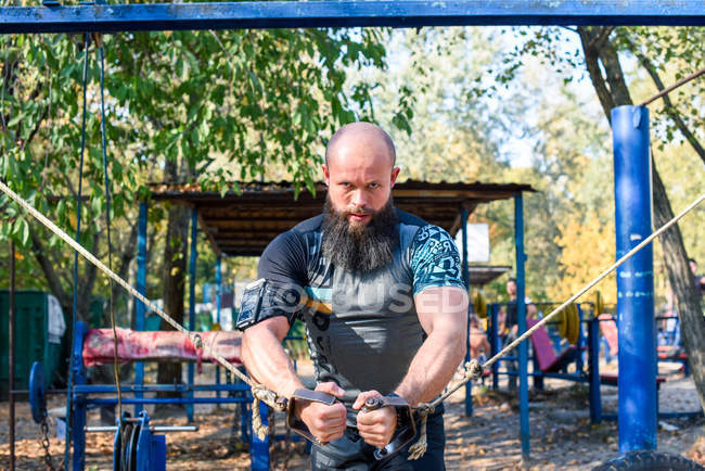 Uomo muscolare facendo esercizi con pesi — Foto stock