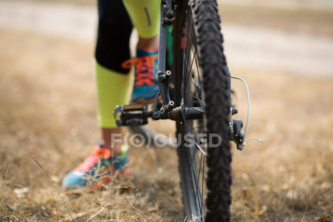 Vélo avec cycliste sur herbe sèche — Photo de stock