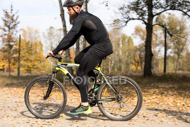 Barbudo hombre ciclismo en el parque - foto de stock