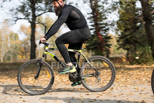 Barbudo hombre ciclismo en el parque - foto de stock